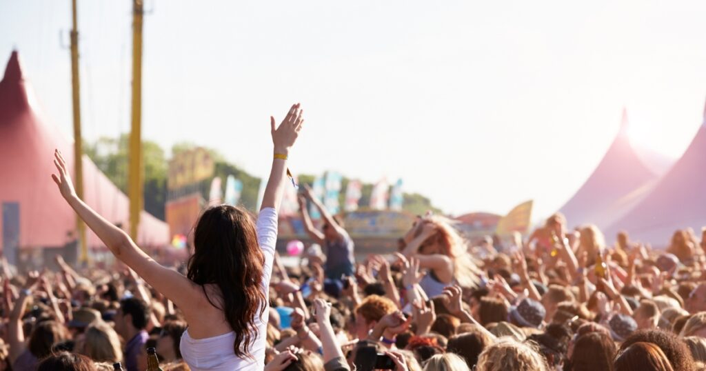 a woman raising her hands in a crowded area